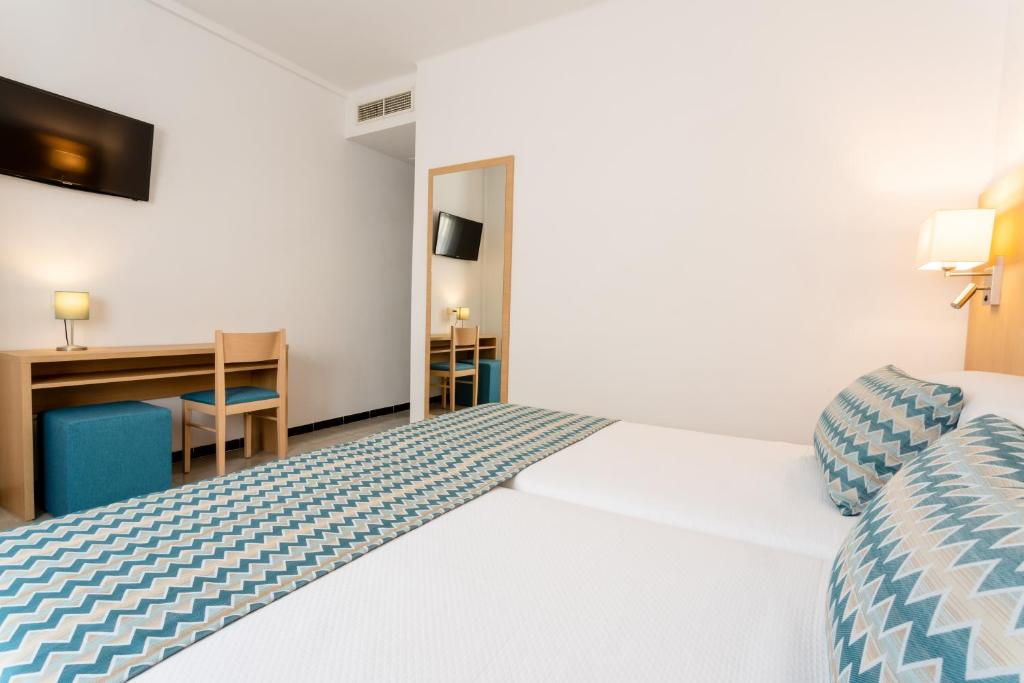 ein Hotelzimmer mit einem Bett und einem Schreibtisch in der Unterkunft Hotel Riutort in El Arenal
