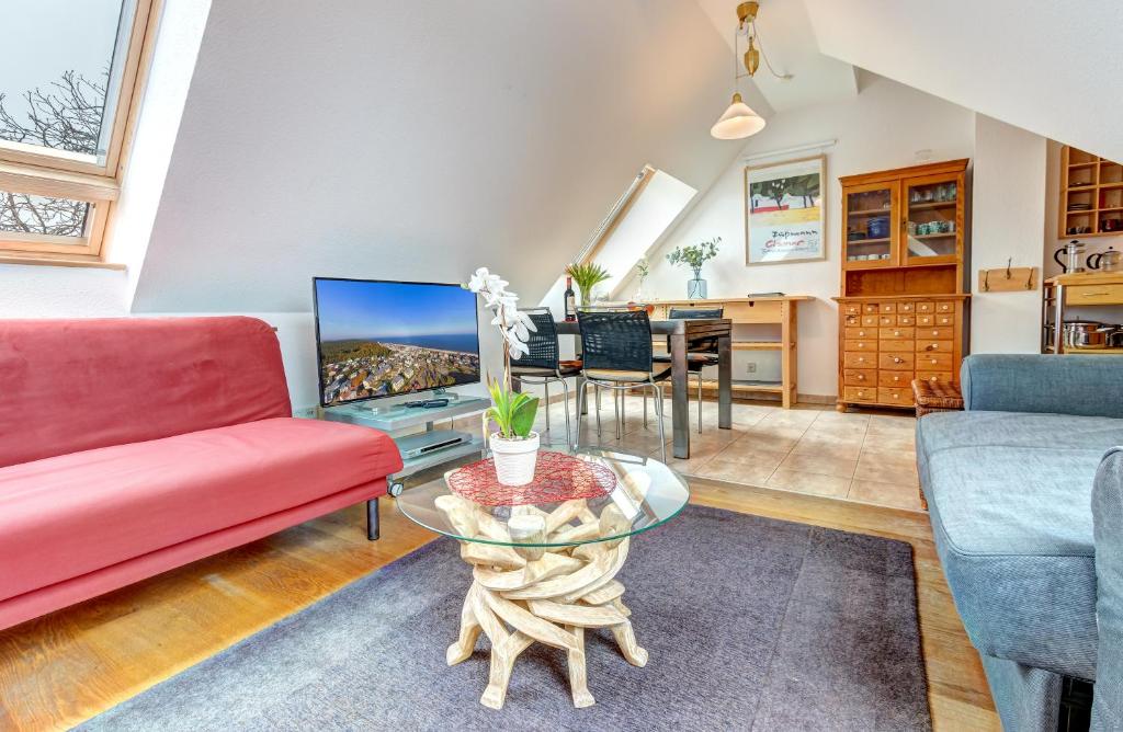 ein Wohnzimmer mit einem roten Sofa und einem Tisch in der Unterkunft Villa Frisia Whg. 31 in Bansin