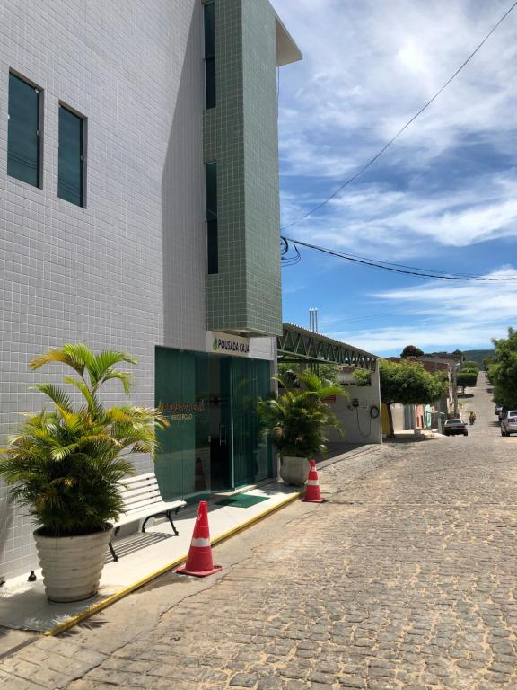 a building with a bench and orange cones on a street at POUSADA CAJÁ in Flores