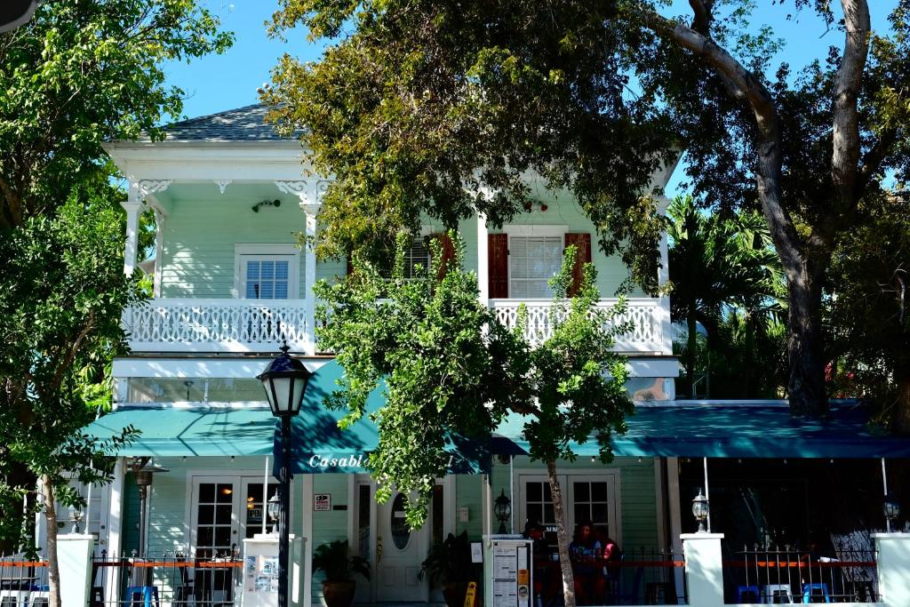 a white house with a balcony on a street at The Casablanca Hotel in Key West