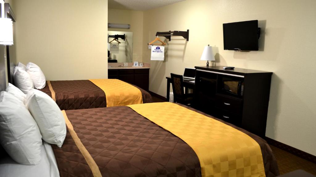 a hotel room with two beds and a television at Americas Best Value Inn Calimesa in Calimesa