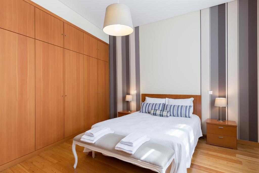 - une chambre avec un lit blanc et des placards en bois dans l'établissement OPO 52, à Porto