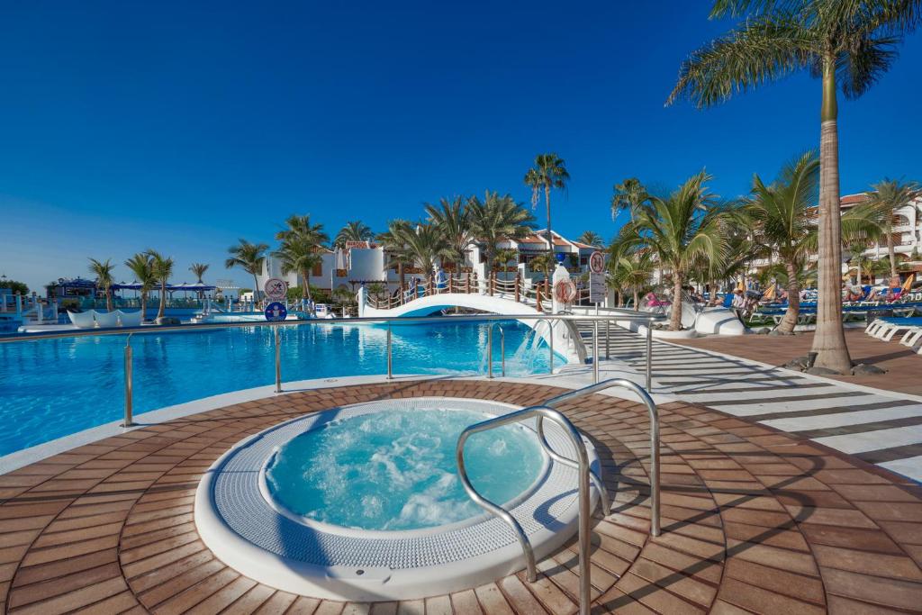 a hot tub at a resort with a swimming pool at Parque Santiago III Official in Playa de las Americas