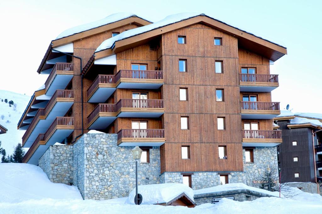 ein großes Gebäude mit Schnee davor in der Unterkunft VVF Résidence Méribel Les 3 Vallées in Méribel