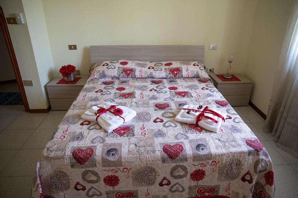 Un dormitorio con una cama con corazones. en B&B Le Magnolie en Amorosi