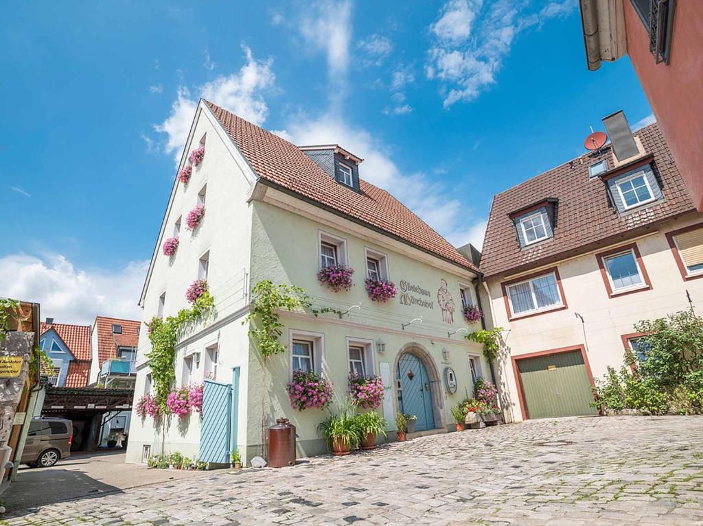 a white building with flowers on it on a street at Gästehaus Mönchshof in Sommerhausen