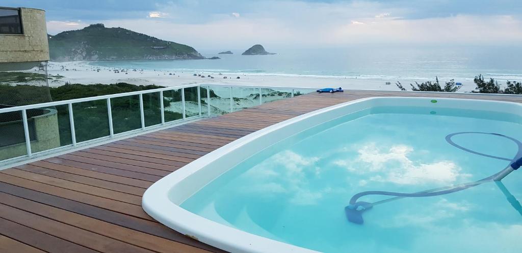 einen Whirlpool auf einer Terrasse mit Blick auf den Strand in der Unterkunft Aparts da Praia Grande 301 in Arraial do Cabo