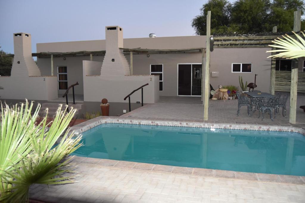 - une piscine en face d'une maison dans l'établissement Kalahari Farmstall, à Koës
