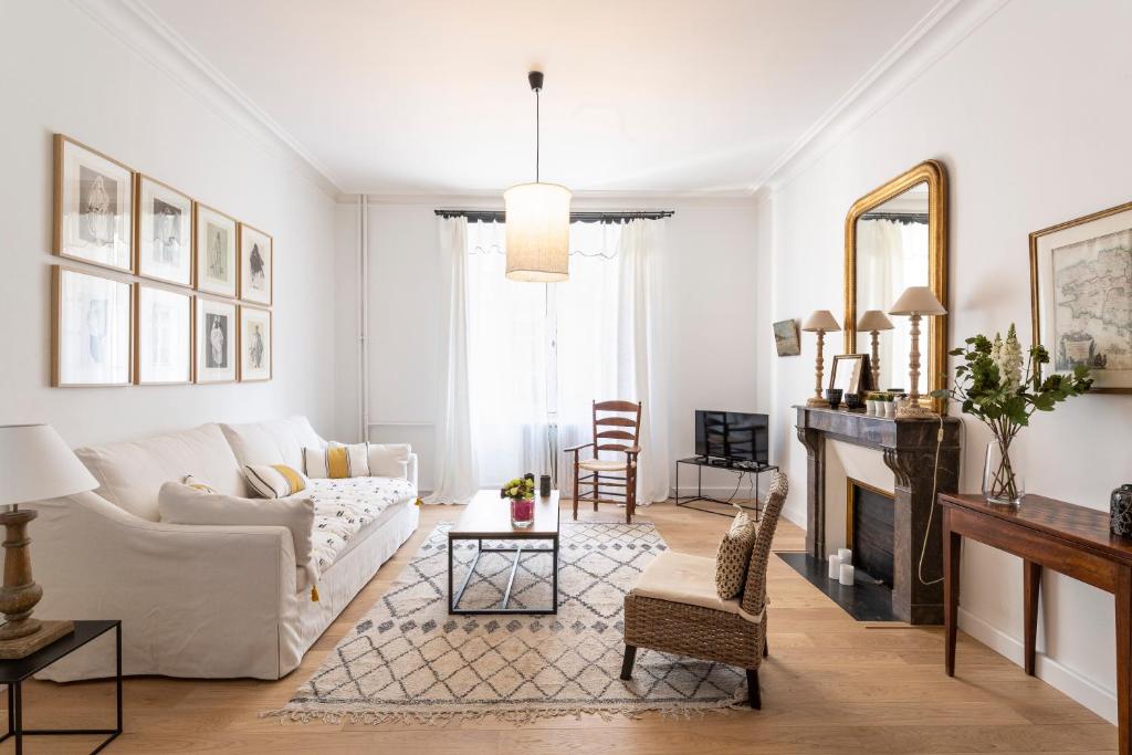 un salon avec un canapé blanc et une cheminée dans l'établissement LE RECIT by Cocoonr, à Rennes