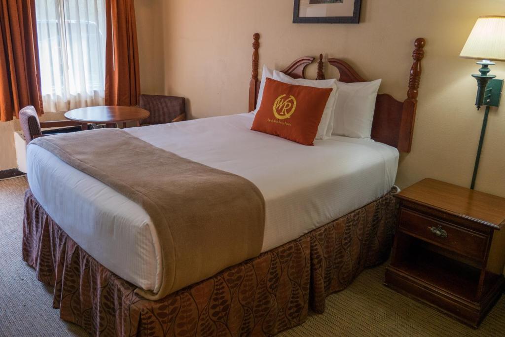 a hotel room with a large bed and a table at Wild Bear Inn in Pigeon Forge