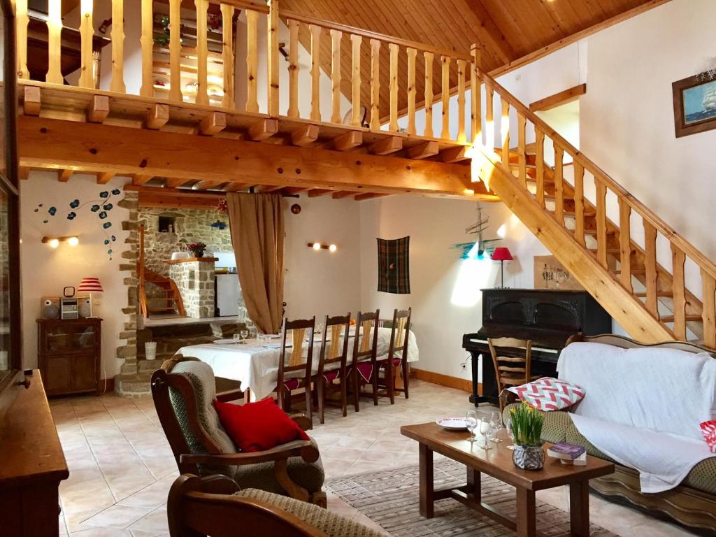 ein Wohnzimmer mit einer Treppe, einem Tisch und Stühlen in der Unterkunft la maison perchée in Le Vast