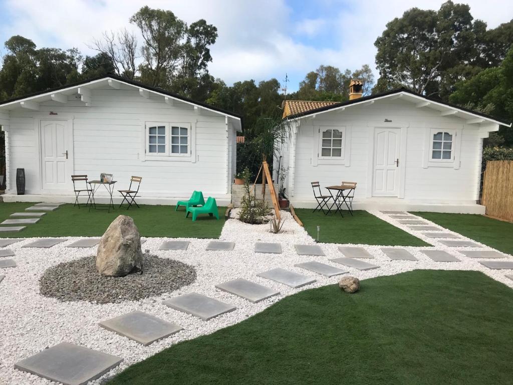 un patio trasero con una casa blanca y césped en Casas de Maderas Wooden Cabin en El Puerto de Santa María