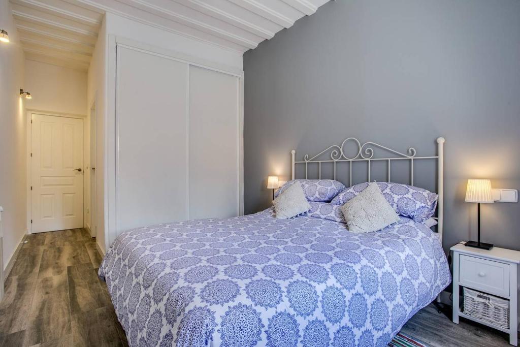 1 dormitorio con 1 cama con edredón y almohadas azules en Casa La Cuadra, en Brunete