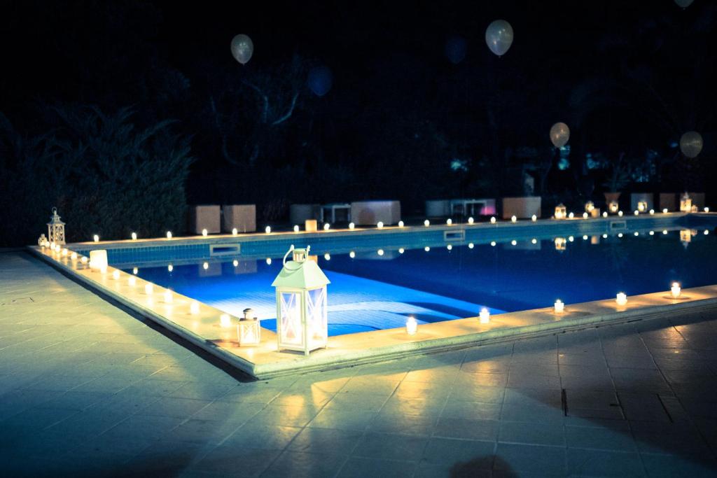 a swimming pool with lit candles in the middle at Agriturismo Messer Gesualdo in Nociglia