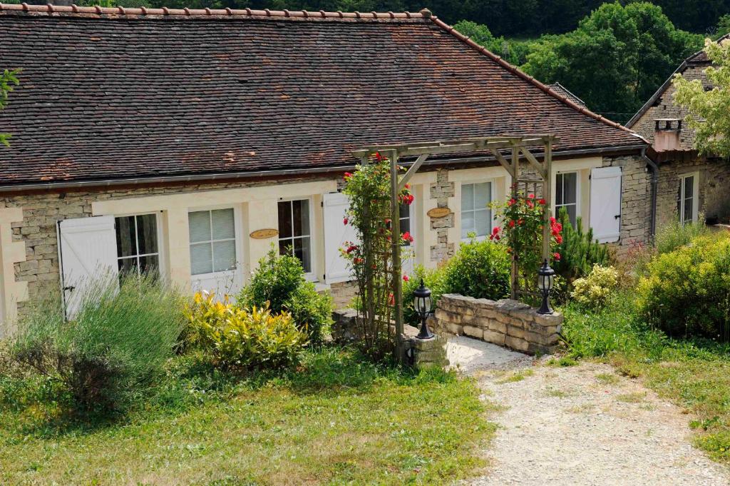 una casa de piedra con un jardín delante de ella en LE GOLURET Chambres & Table d'hôtes - Espace Bien Être en Couvignon