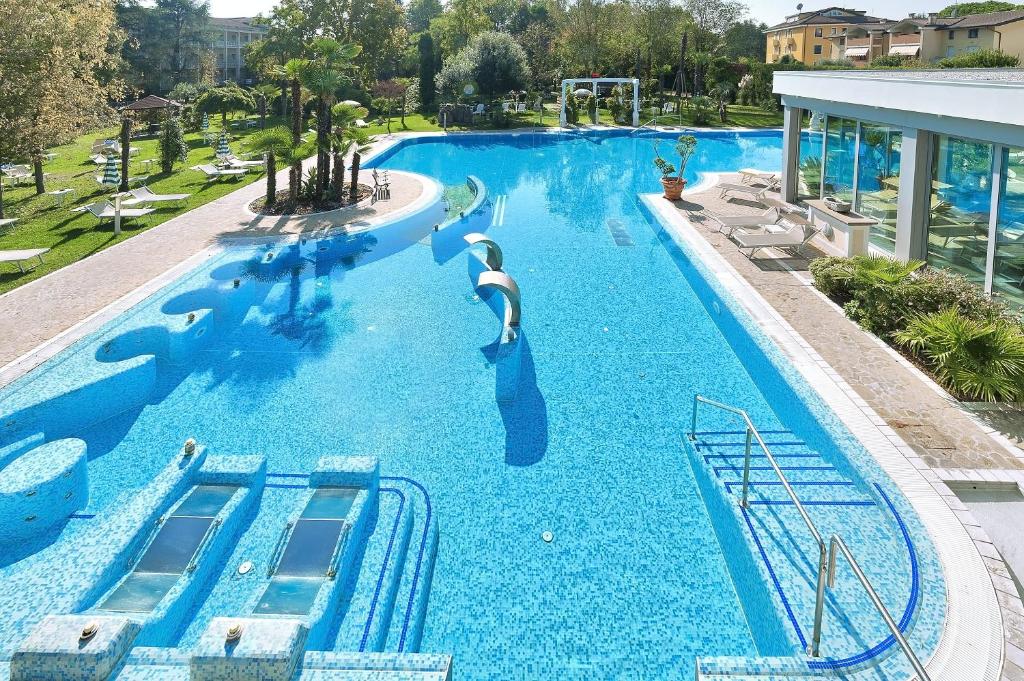 una gran piscina con un tobogán en un complejo en Hotel Harrys' Garden, en Abano Terme