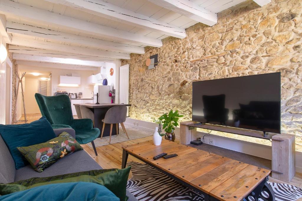 Il comprend un salon doté d'un mur en pierre et d'une télévision à écran plat. dans l'établissement Le Sainte Claire, à Annecy