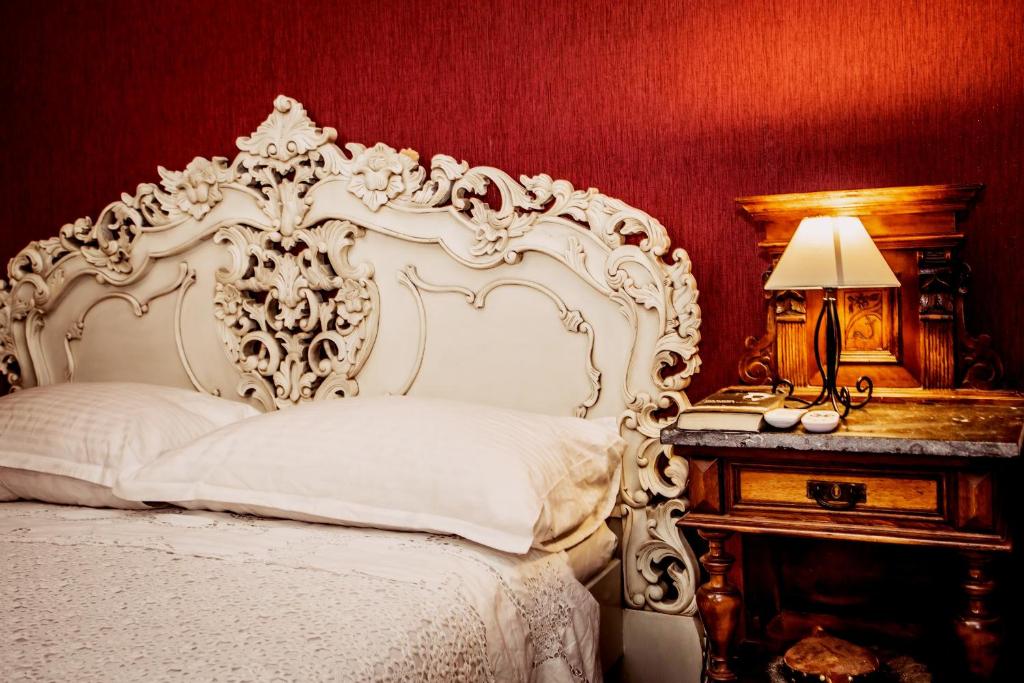 a bedroom with a white bed and a table with a lamp at Villa Residence Burgus-Antium in Trogir