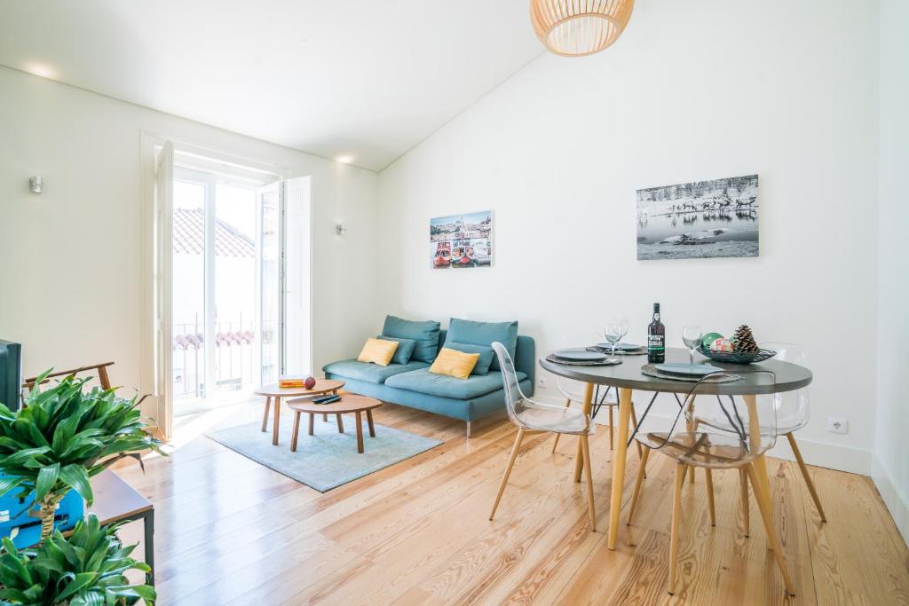 a living room with a blue couch and a table at Liberdade Apartment in Lisbon