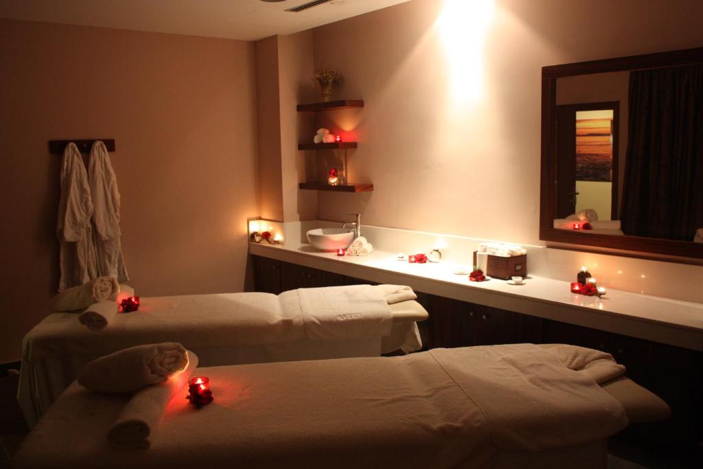 a room with two beds and a mirror at Capital Coast Resort And Spa in Paphos