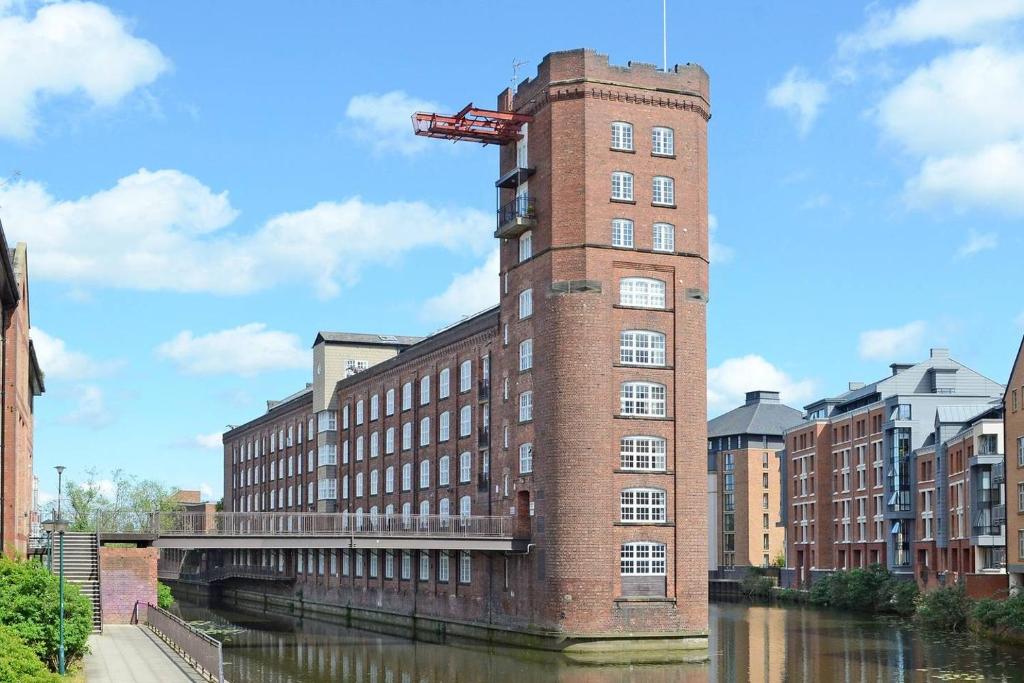 un edificio in mattoni con una gru sul lato di un fiume di Riverside Studio Apartments Close To City Centre a York