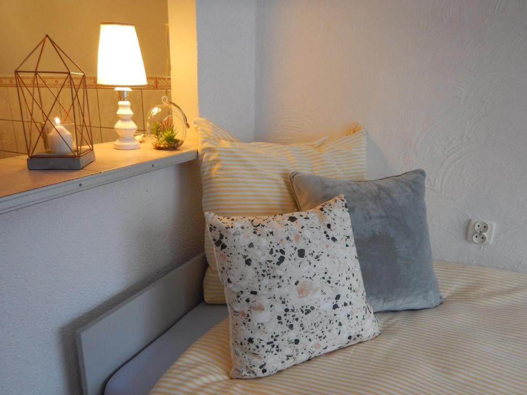 a bed with two pillows and a lamp on it at Apartament Piastowska in Kamienna Góra