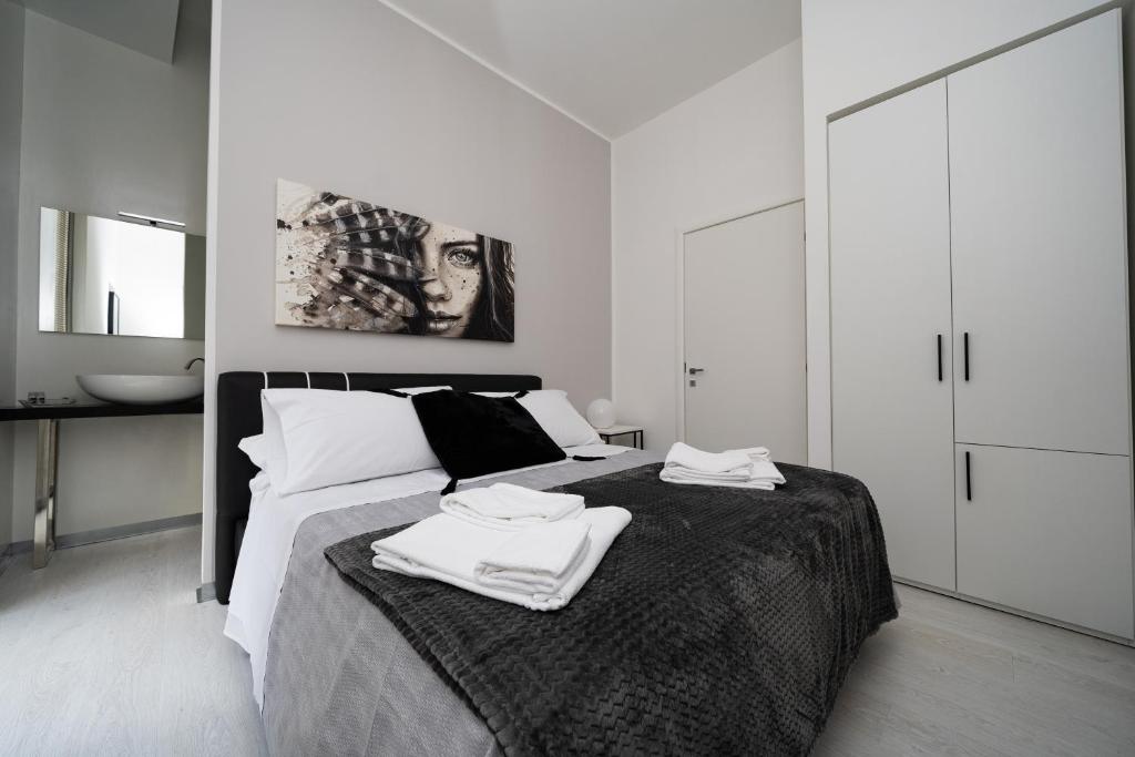 1 dormitorio con 1 cama con 2 toallas en White Rooms en Reggio Calabria