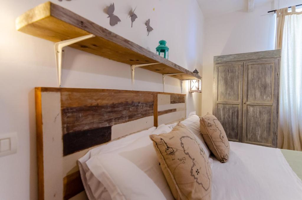 a bedroom with a white bed with a wooden headboard at Domatia in Barletta