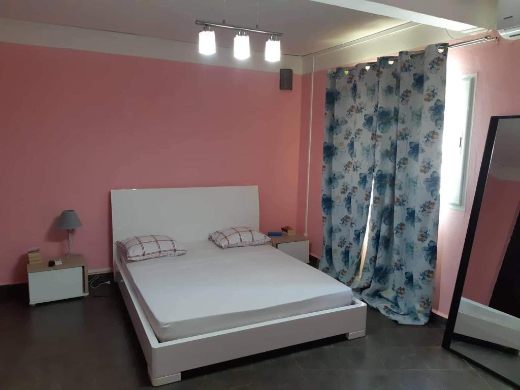- une petite chambre avec un lit blanc et une fenêtre dans l'établissement CACAO LODGE, à Mamoudzou