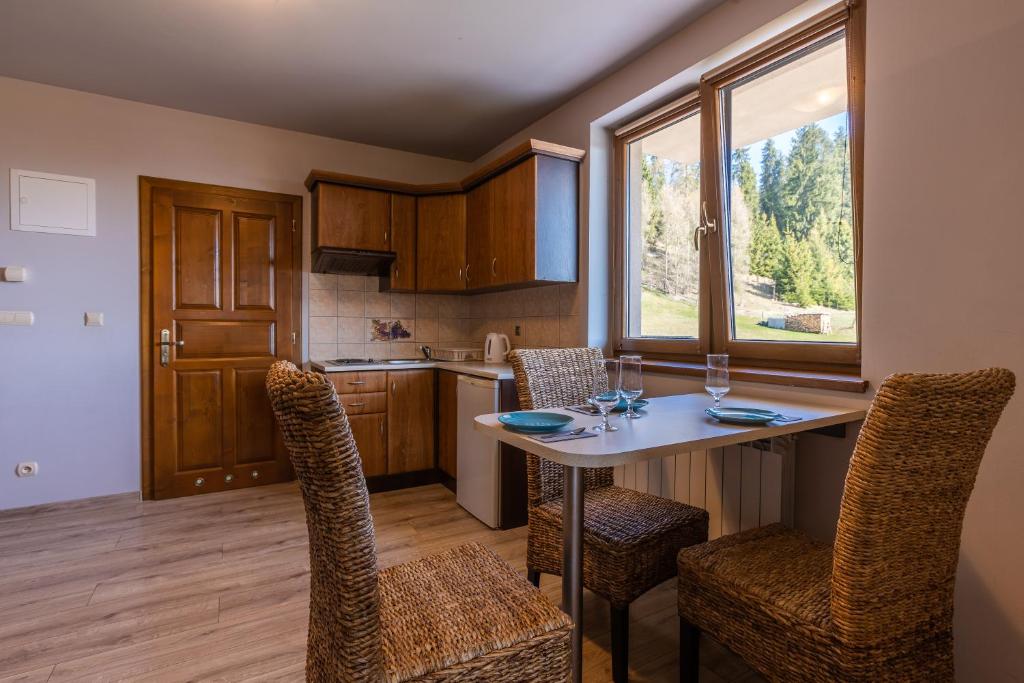 a kitchen and dining room with a table and chairs at Willa Uroki Spisza in Łapsze Niżne