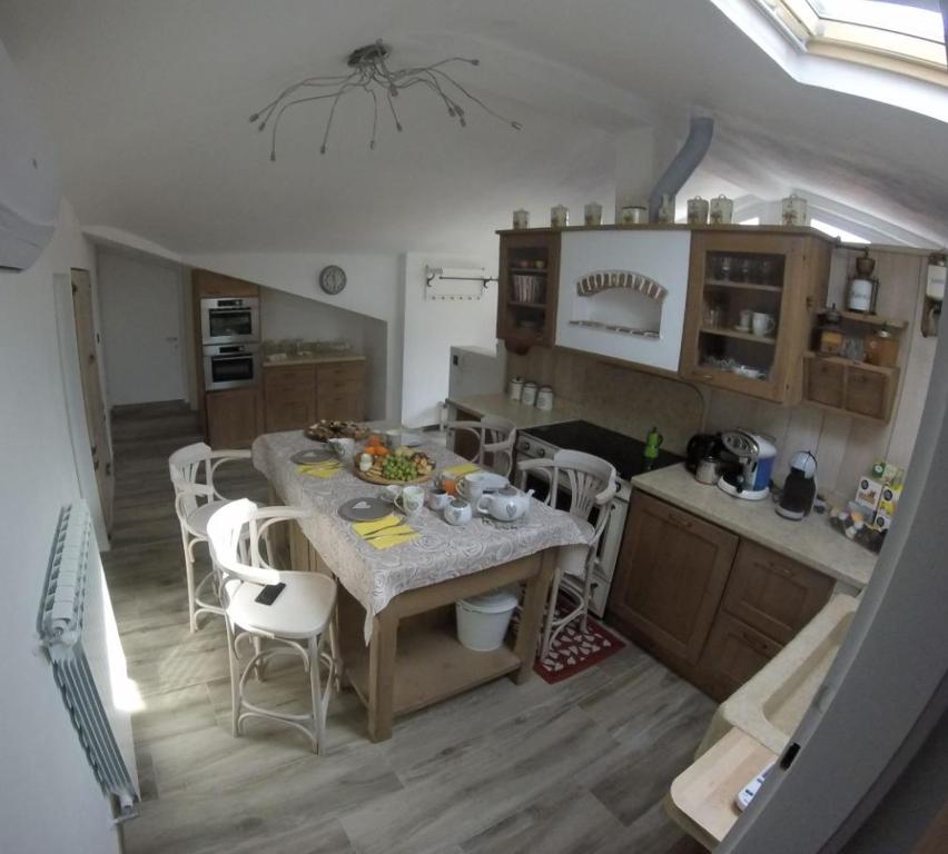 uma cozinha com mesa e cadeiras num quarto em SERENDIPITY BED & RELAX em Muggia