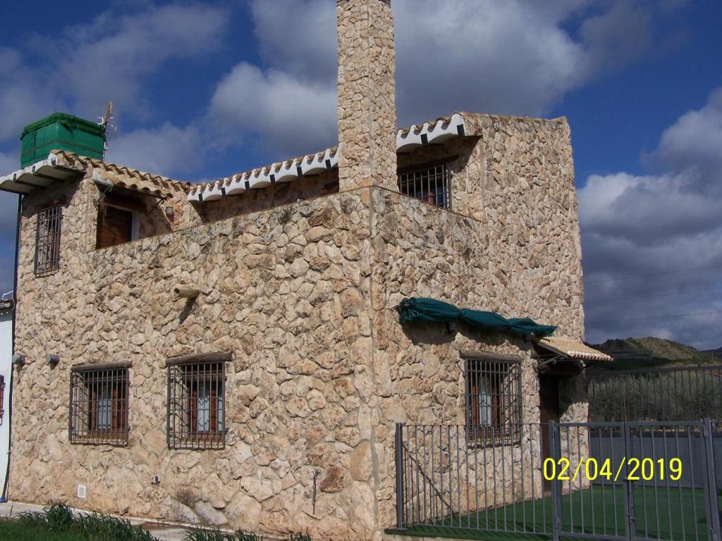 a stone building with a chimney on top of it at Casa Rural Altozano Elche de la Sierra in Elche de la Sierra