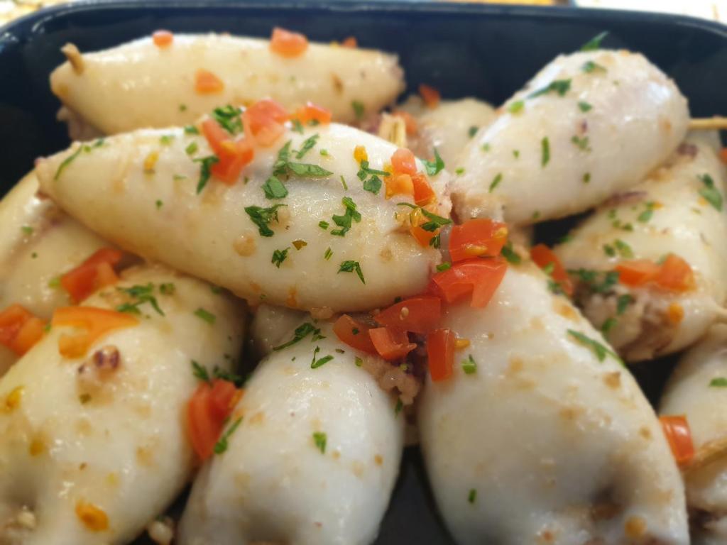 a blue bowl filled with dumplings with carrots on top at Casa Mafalda in Chioggia