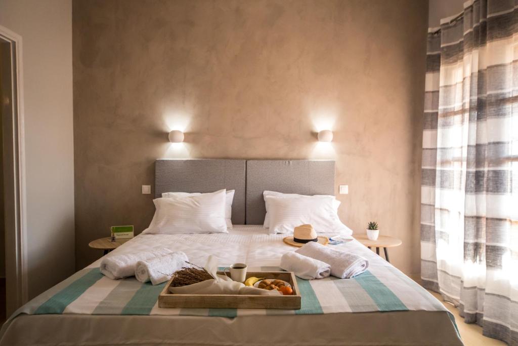 a hotel room with a bed with a tray of food on it at The Lake Apartments in Kommeno