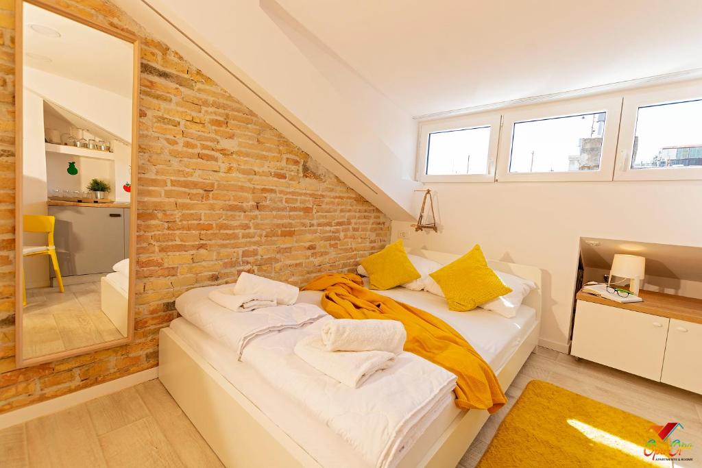 a bedroom with a bed with a brick wall at Apartments Opa Opa in Rijeka