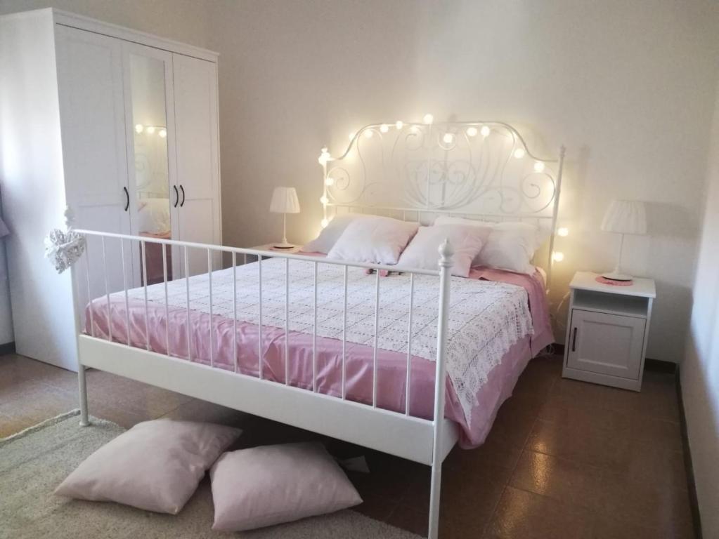 een slaapkamer met een wit bed met roze lakens en kussens bij Pisa apartment in Pisa