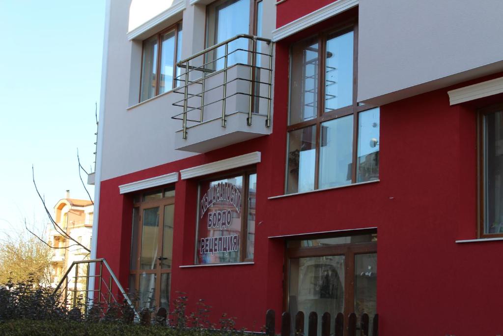 a red building with a sign in the window at Guest House Bordo in Obzor