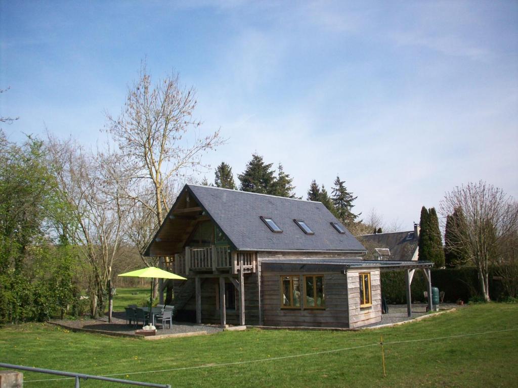 una pequeña casa de madera con techo en un patio en La Trouverie, en Pleines-Oeuvres
