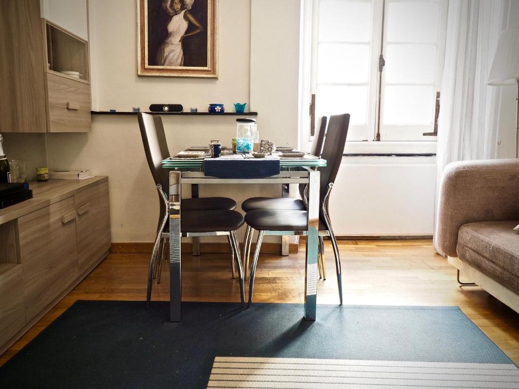 - une cuisine avec une table et des chaises dans la chambre dans l'établissement CASA DEGLI INDORATORI ACQUARIO - GENOVABNB it, à Gênes
