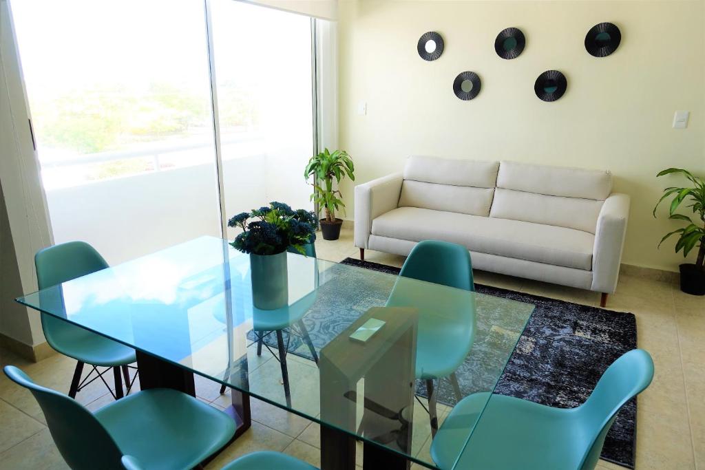 salon ze szklanym stołem i krzesłami w obiekcie Ideal tu casa fuera de casa w mieście Cancún