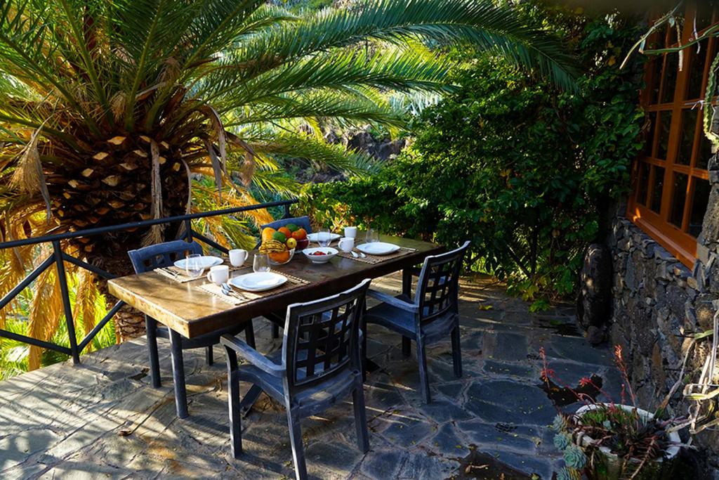 Une table et des chaises en bois sont disponibles sur la terrasse. dans l'établissement CASA RURAL LOS FRONTONES, à San Sebastián de la Gomera