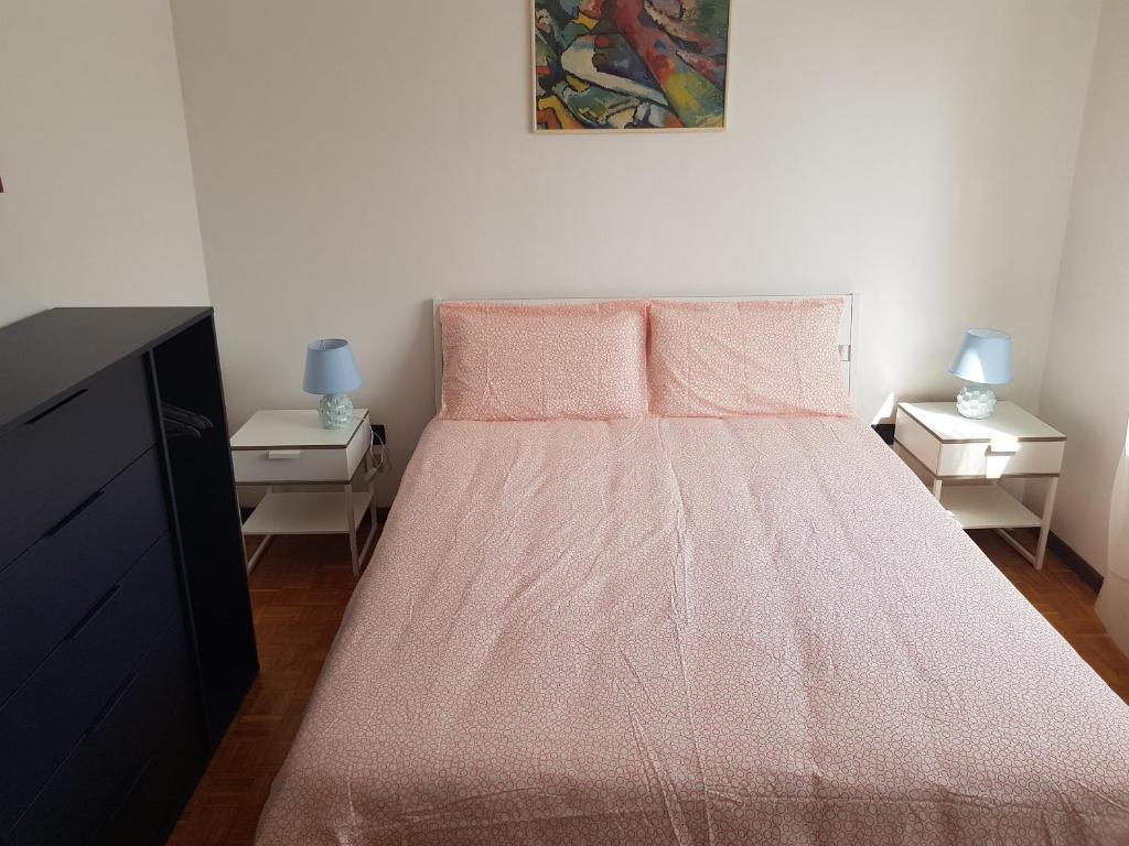 a bedroom with a bed with a pink bedspread at Foresteria Giulia in Bergamo