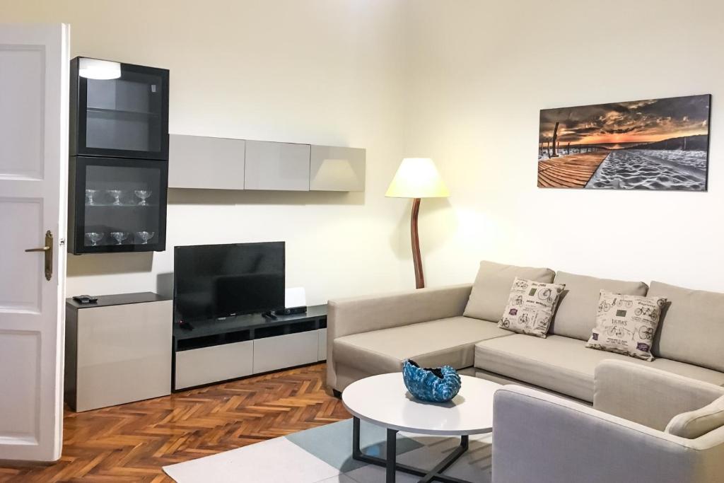 a living room with a couch and a tv at Budapest Kingdom Apartment CENTRAL & CAR PARKING ON-SITE & AIRCON & QUIET & FAMILY FRIENDLY in Budapest