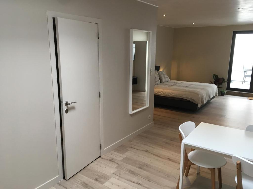 een kamer met een deur en een bed en een tafel bij Studio 't Ponton in Nieuwpoort