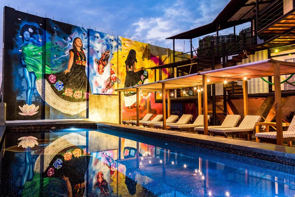 una piscina con un mural en el lateral de un edificio en Cabane Container Boutique Hotel - ADULTS ONLY en Puerto Escondido
