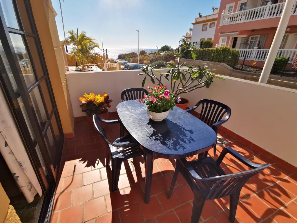 einen blauen Tisch und Stühle auf einem Balkon mit Blumen in der Unterkunft Apartamento Verode in Puerto Naos