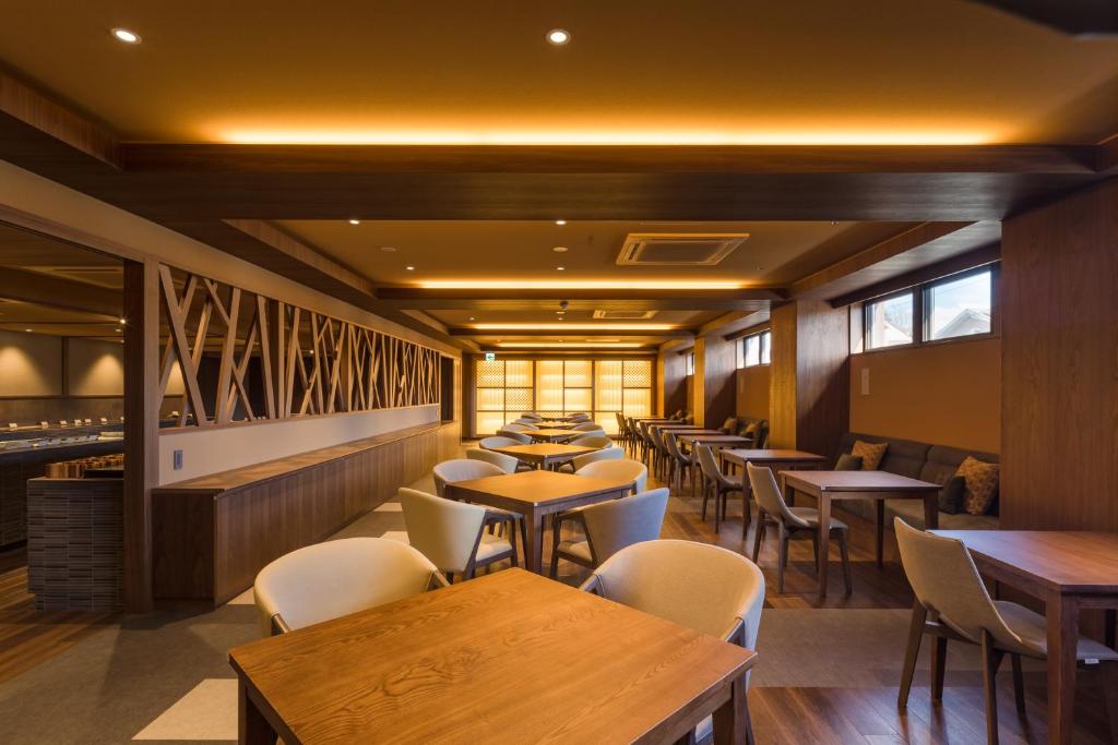 a restaurant with tables and chairs and a bar at Oike Hotel in Fujikawaguchiko