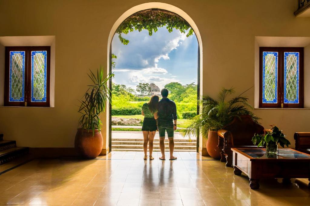 a couple standing in front of an open door at Mayaland Hotel & Bungalows in Chichén-Itzá
