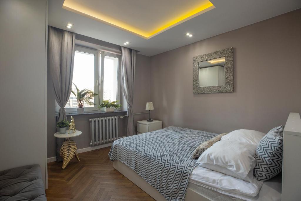sypialnia z łóżkiem i oknem w obiekcie Little Home Apartments w Warszawie