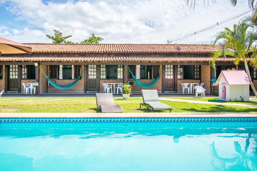 una casa con piscina frente a una casa en Pousada Casuarina Geribá, en Búzios